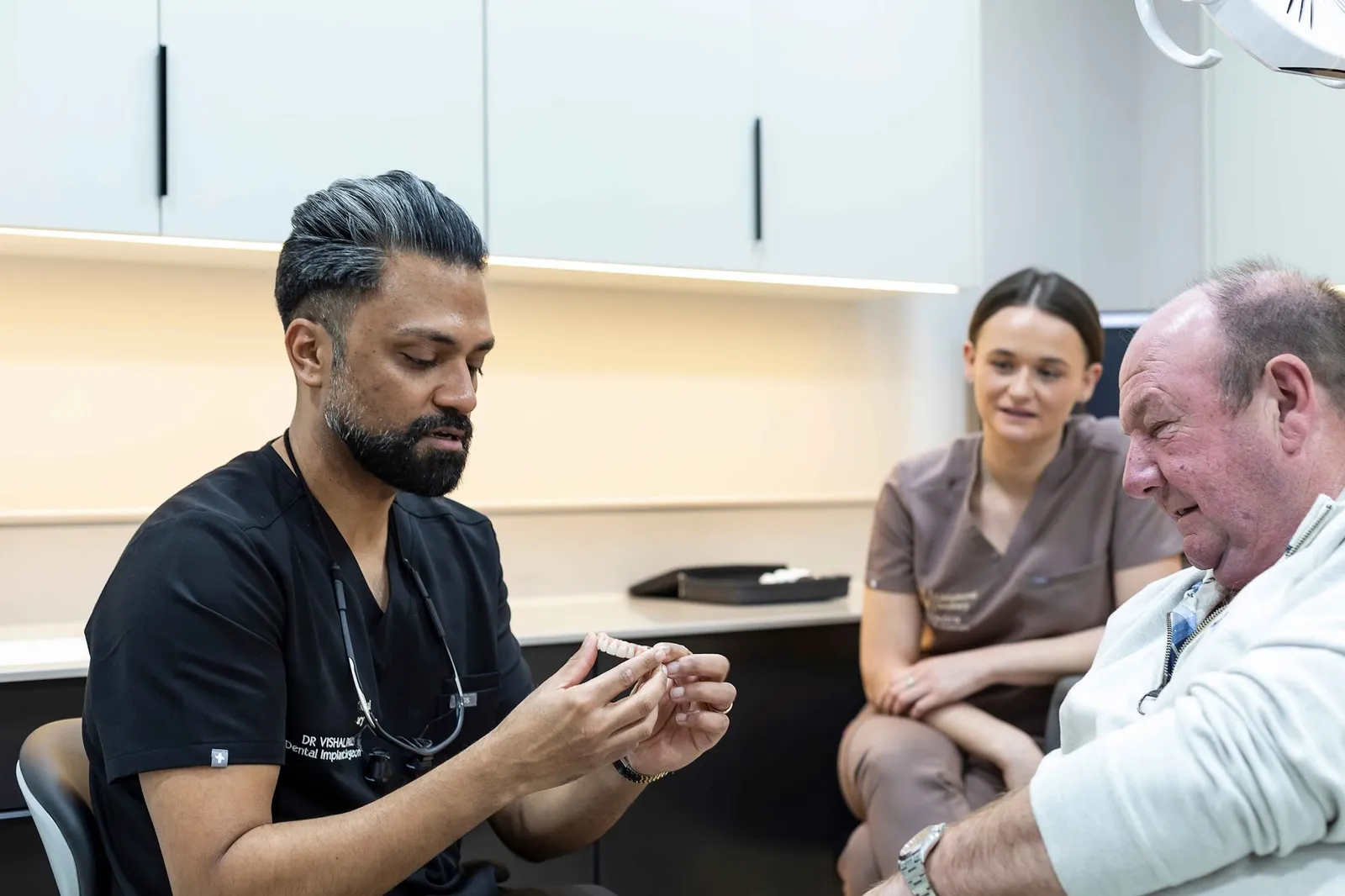 Implant dentist Dr Vish discussing full arch dental implant treatment with a patient