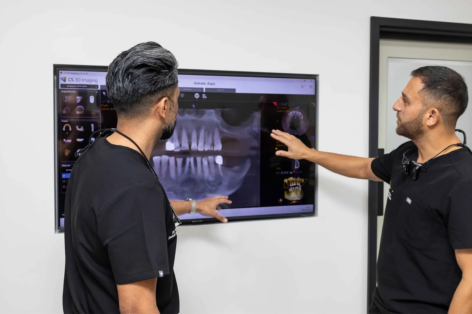 Dental team reviewing a 3D CBCT scan for dental implant treatment planning